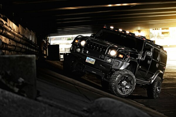 Un Hummer todoterreno negro se aleja de la carretera