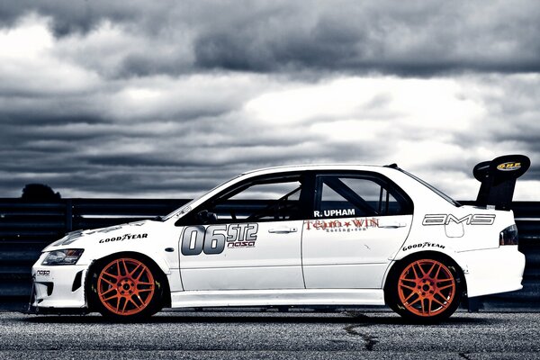 White sports car on the background of gray clouds