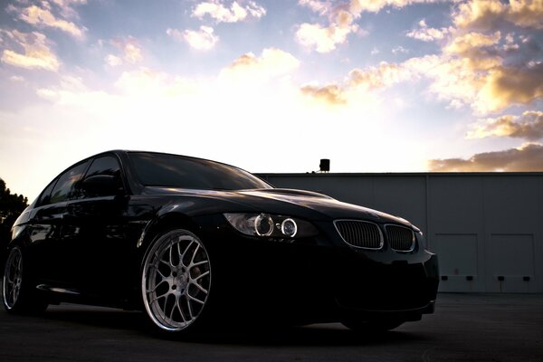 Czarne BMW stoi na tle chmur