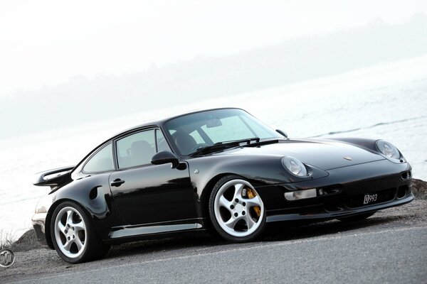 Porsche negro en carretera grabada