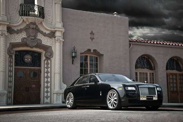 Black Rolls Royce on the background of the building