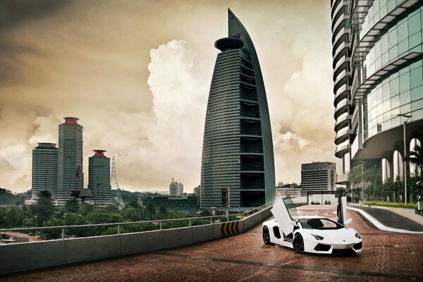 Cielo y nubes sobre la ciudad de Kuala Lumpur y en su fondo Lamborghini Aventador lp700-4