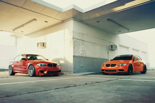 Dwa czerwone bmw M3 i 1M na parkingu