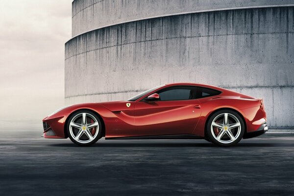 A beautiful, red car stands against a gloomy background