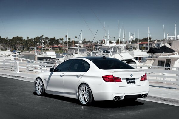 Bmw série 5 blanche chic sur le quai avec des yachts