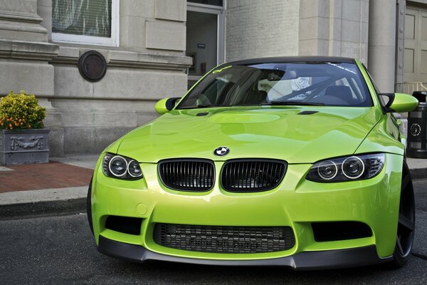 Green BMW on the background of the wall