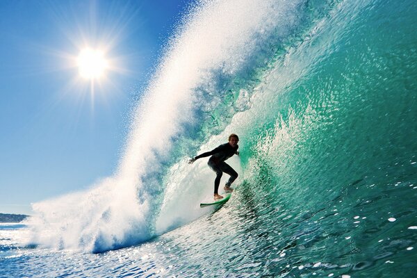 Ein Surfer auf einem Brett und eine riesige Welle