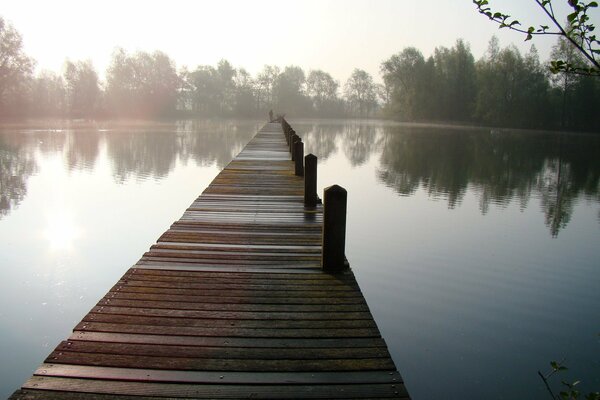 Wooden bridge on misty lake