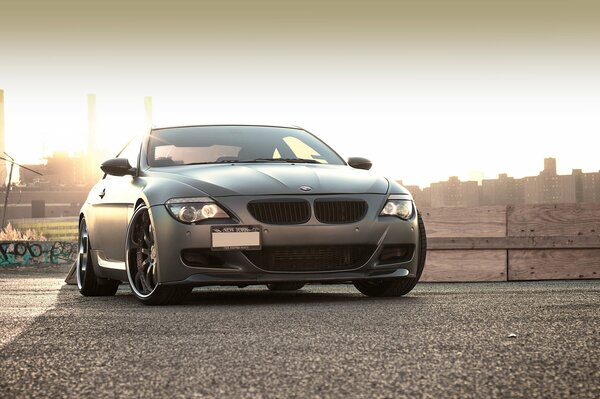 Grey matte BMW car on the road against the ghetto background