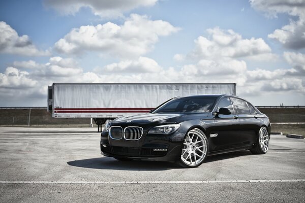 Black bmw on the highway under a cloudy sky