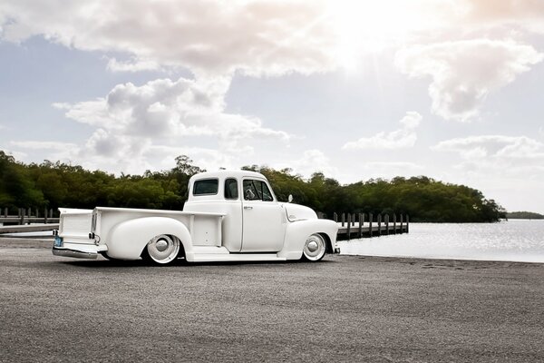 White car on the lake shore