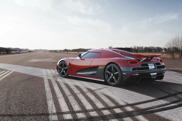 Supercar rouge sur une route déserte