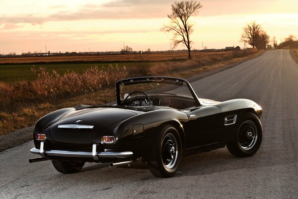 BMW convertible on the background of a rustic sunset