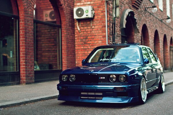 A blue car at a brick building