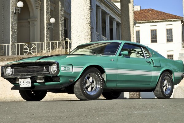 Mustang verde en el fondo de la ciudad