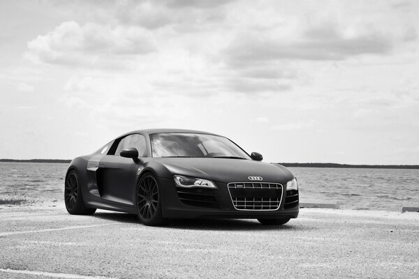 Black and white photo of Audi on the seashore