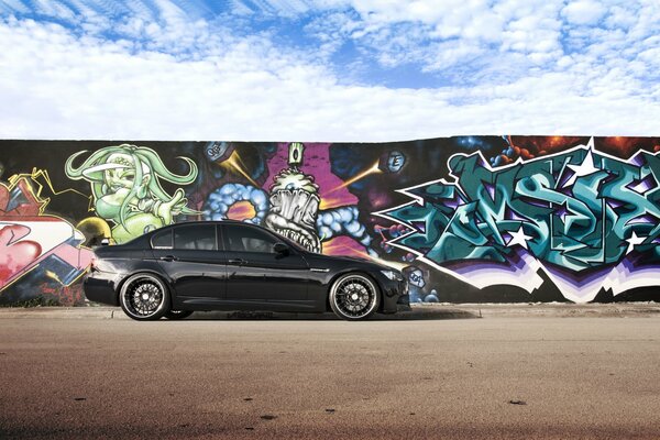 BMW noir sur fond de mur avec graffiti