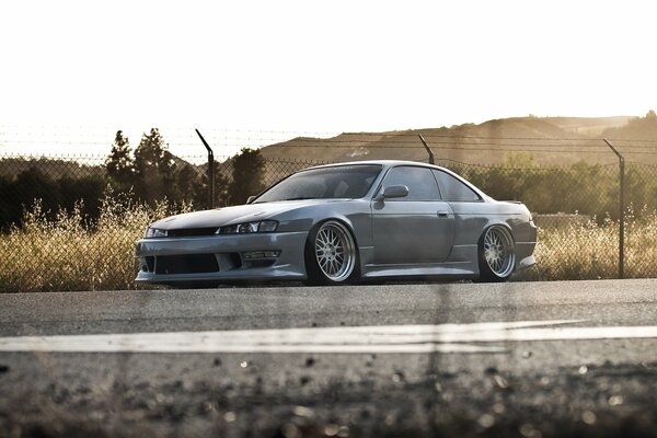 Nissan Sylvia in gray on a fence background