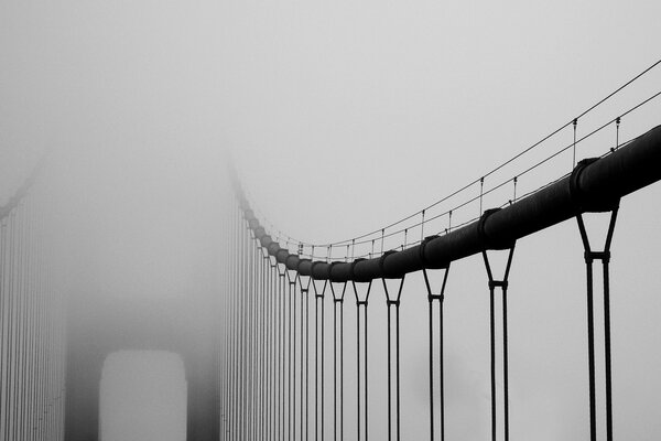 Puente colgante por la mañana brumosa