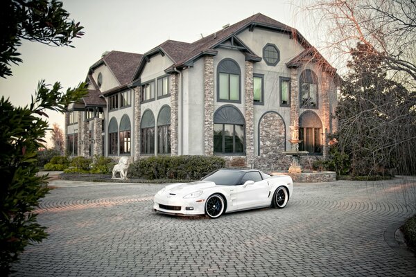 Chevrolet corvette white on the background of the mansion