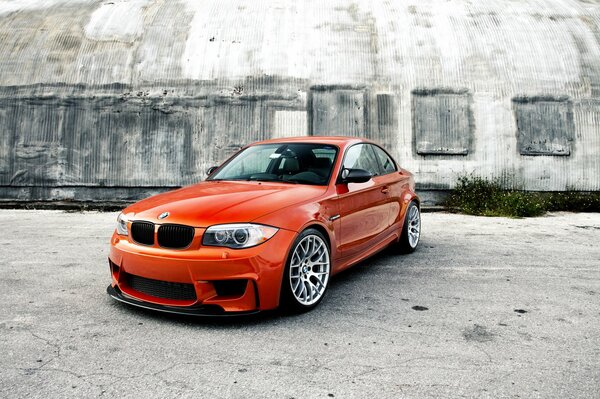 There is an orange car on the road