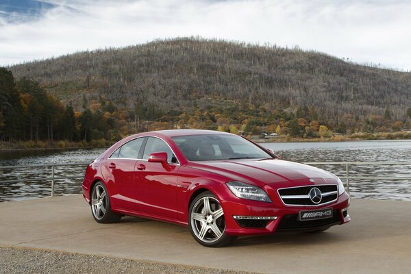 Himmel, Berg, Wald und rote Mercedes-Limousine cls63 am Seeufer