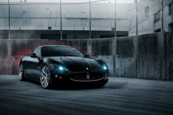 Black Maserati in darkness and fog