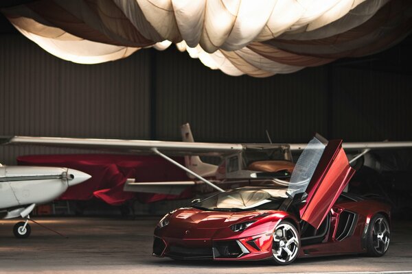 Red Lamborghini in the background of an airplane