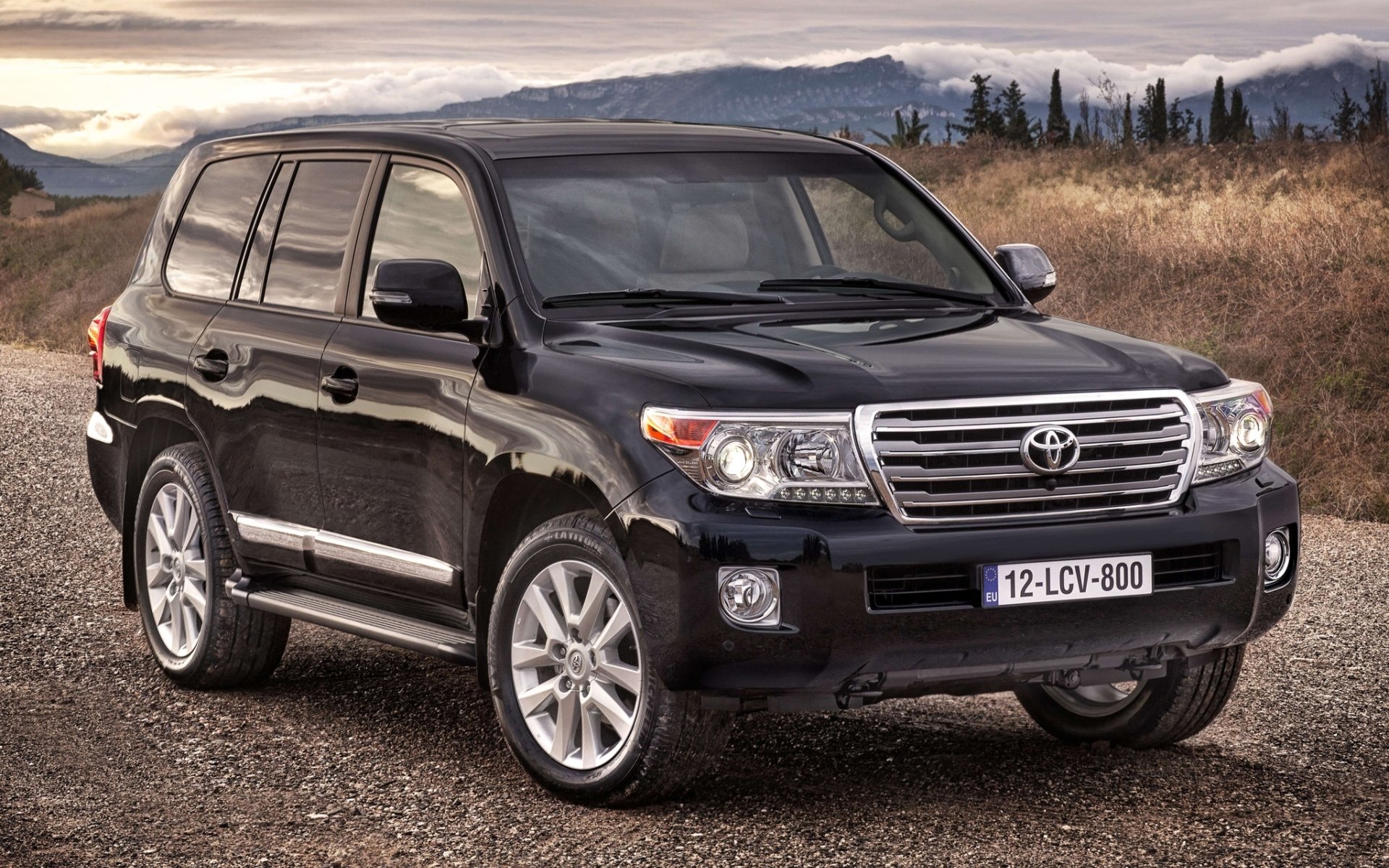 toyota land cruiser toyota land cruiser cruzak przód jeep suv droga pole drzewa góry niebo