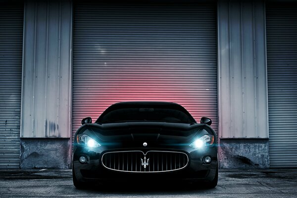 Black maserati. Light from yellow headlights