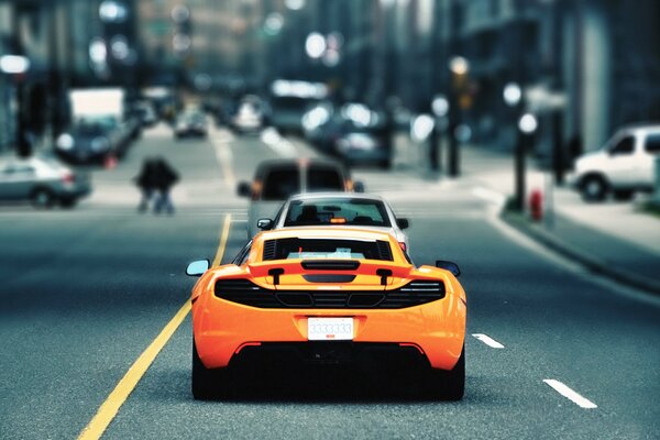 Orange mclaren on the road in the city