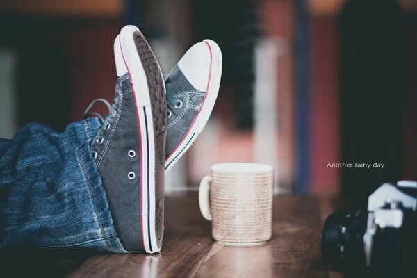 Piernas en Zapatillas tiradas sobre la mesa