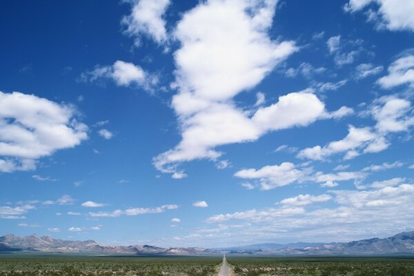 The road leading into the distance which is decorated with the sky in the clouds