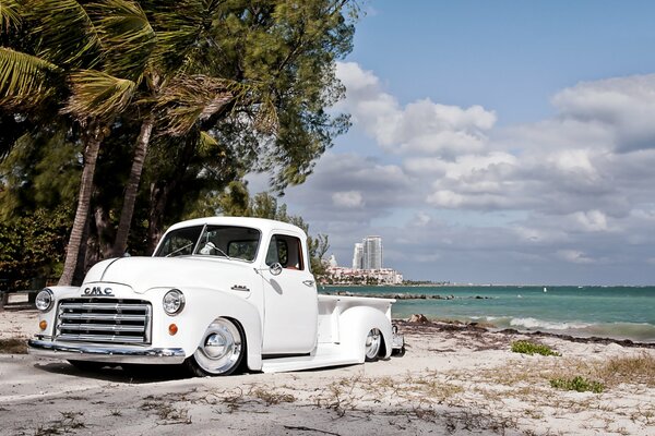 Biały retro pickup GMC na tle plaży i Palm