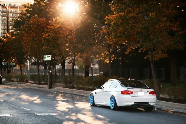 Weißer BMW auf blauen Scheiben auf der Straße