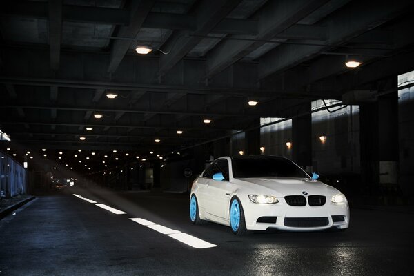 White bmw on blue discs on the road