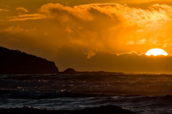 Sonnenuntergang in der Wolke auf dem Hintergrund des Meeres