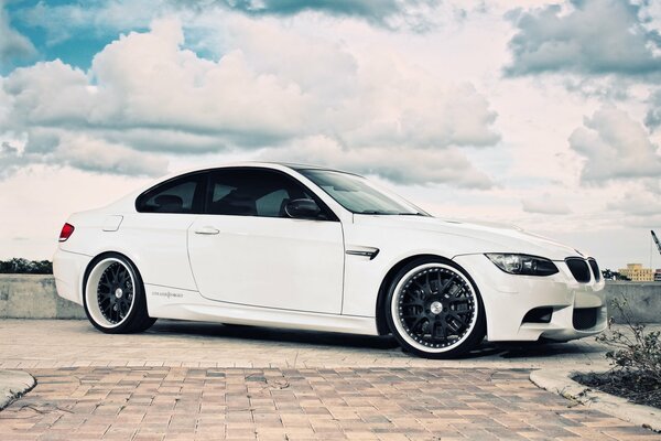 White BMW on the road among the clouds