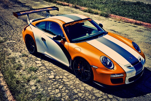 Porsche orange sur une route déserte