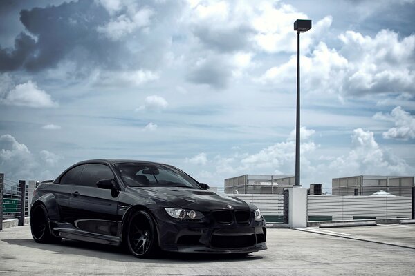 Schwarzes bmw Cabrio unter dem Himmel mit Wolken