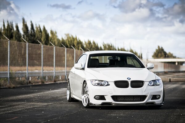 Photo of a white BMW 3 series on asphalt