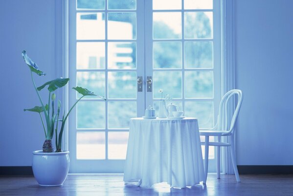 A table with a white tablecloth by the door