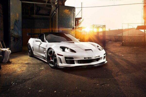 White chevrolet, corvette, ZR1, tikt three-seater on asphalt in the sunset