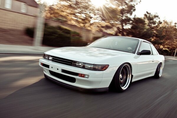 Blanco Nissan Silvia s13 en movimiento a través de la ciudad