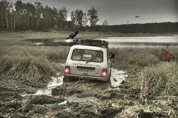 Un acosador de Chernobyl, Niva atrapado en el barro con un Cuervo en el techo. Alrededor del bosque y la radiación