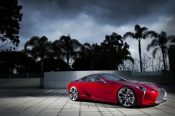 Red Lexus on the background of a landscape with palm trees