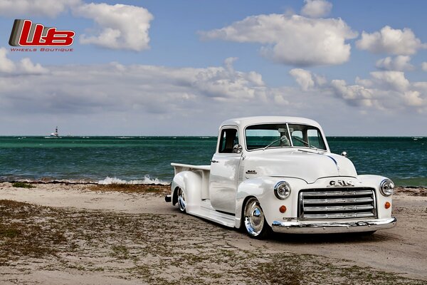 Lowrider bianco sintonizzato sulla spiaggia vicino al mare