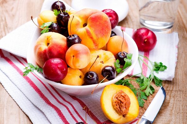 Peaches and plums in a plate. Fruit on the table