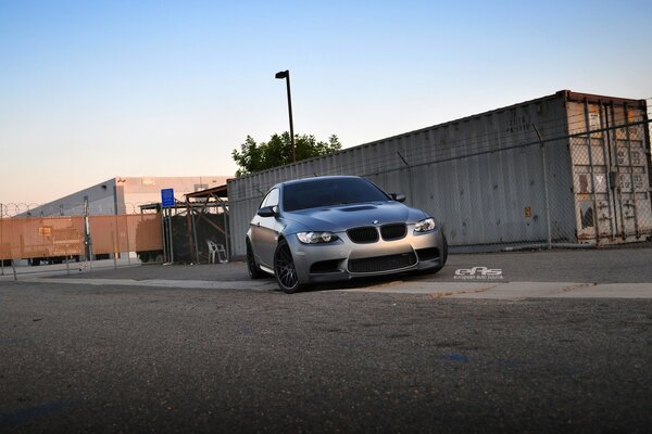 Matte black BMW in the evening at the gate