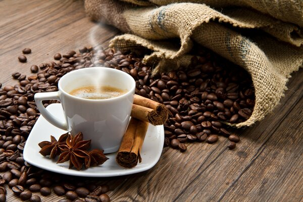 Grains de café et tasse de café à la cannelle